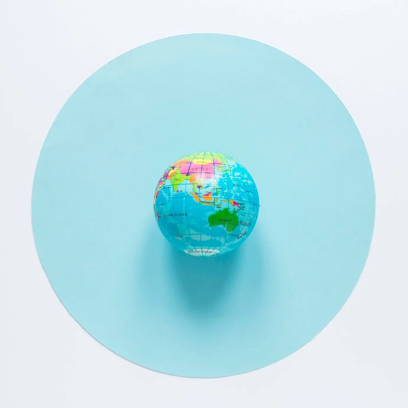 Flatlay-Aufnahme eines Globus auf einem Kreis
